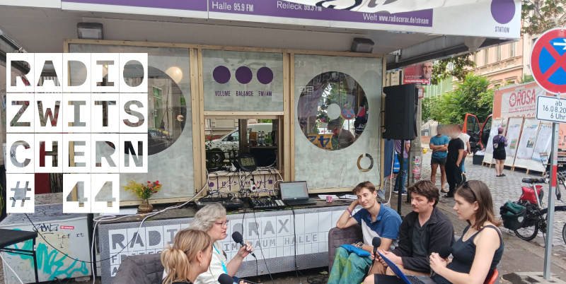 Vier personen sprechen in Mikrofone vor einem Kiosk.